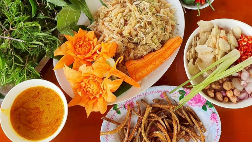 Gỏi cá nhệch ăn kèm với các loại lá, rau, gia vị và chấm cùng nước chẻo, tạo nên hương vị tuyệt vời, khó quên